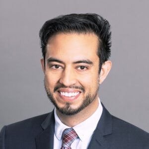 Headshot of Navin Bora from the shoulders up, smiling in a suit and tie. 